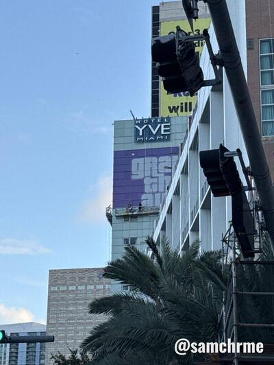 Topo do Hotel YVE Miami com a lona de GTA 6, atrás de um poste de iluminação e de uma palmeira