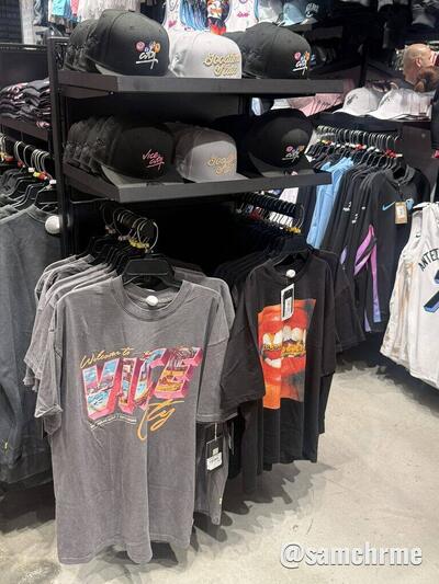 Prateleiras de loja com camisetas e bonés com a marca Vice City