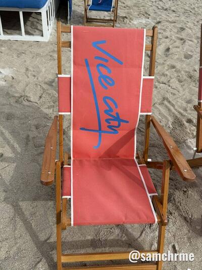Cadeira de praia vermelha com "Vice City" escrito em azul no encosto