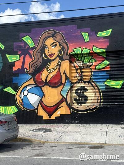 Mulher de biquíni vermelho com bola de praia e saco de dinheiro, pintada num muro à luz do dia