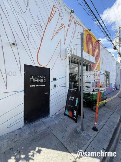 Fachada branca com o desenho a traço do mural "Vice City" e uma plataforma elevatória, numa rua de Wynwood