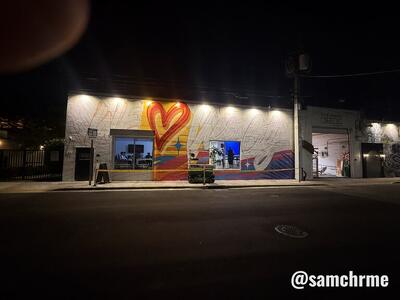 Mural "We ♥ Vice City" iluminado à noite, visto da esquina