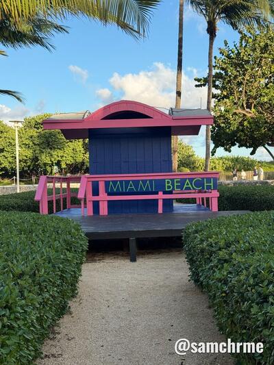 Torre de salva-vidas pintada de azul e rosa com o letreiro Miami Beach no Lummus Park